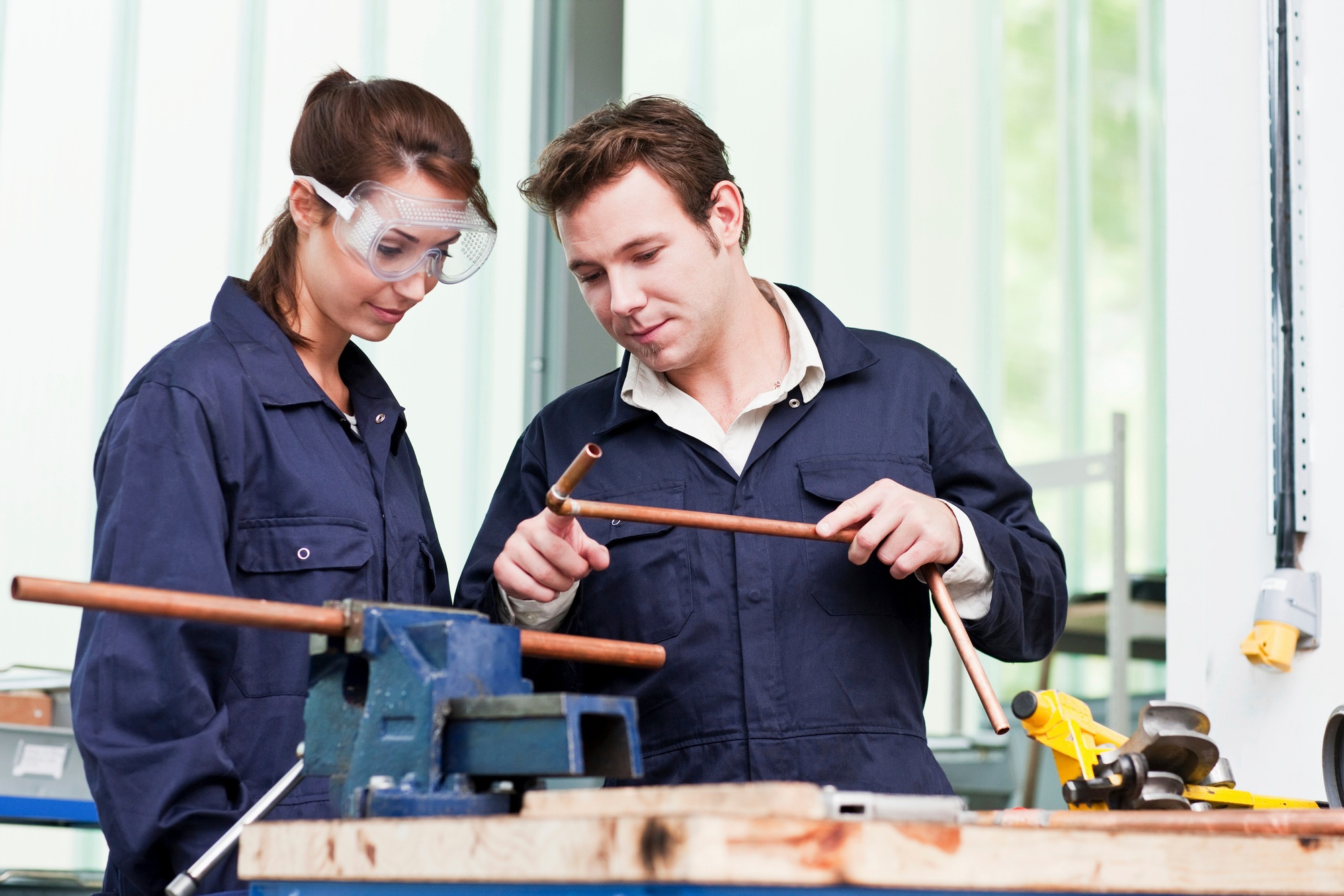 Professional plumber with apprentice in class